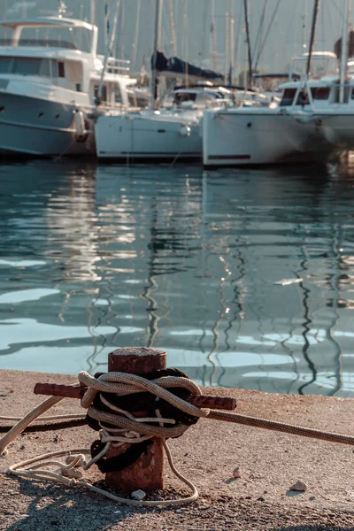 Details of the ship. Fishing nets, knots and ropes in the rays of the sunrise. Reflection in water.