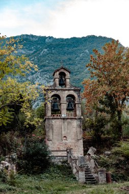 Dağın arka plan üzerinde ayrı çan kulesi. Karadağ, Prcanj kasaba, Doğum Church of Our Lady