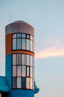 Yuvarlak şeklinde gökyüzüne karşı bina cephe parçası. Günbatımı.