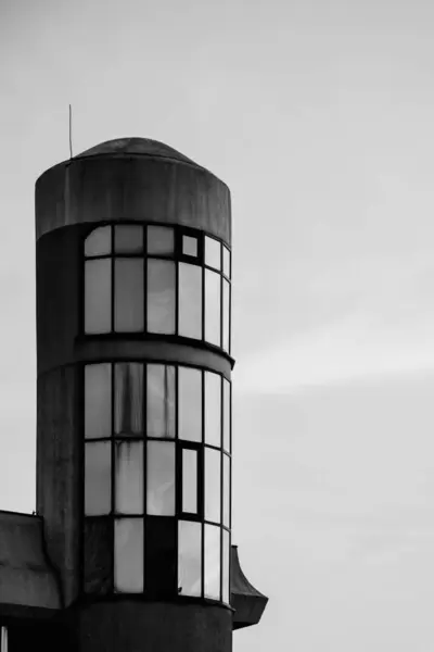 Fragment of the facade building with a rounded shape against the sky. Sunset. Black and white image