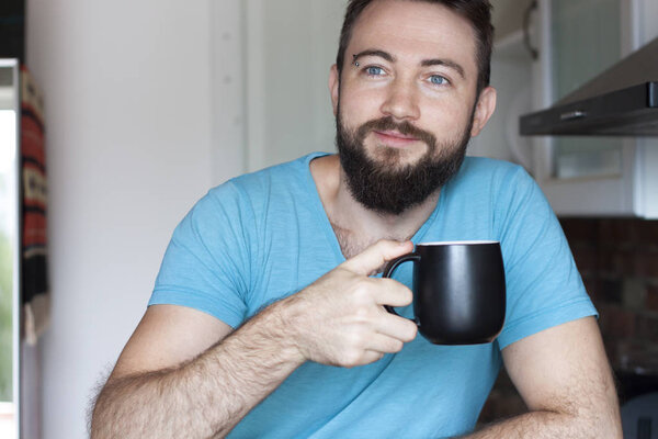 handsome man drinks coffee and looks confident