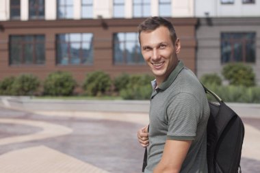 bir sırt çantası ile binanın arka planda neşeli adam sahanın