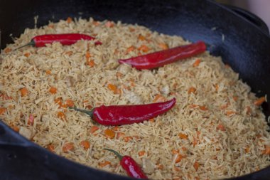 güzel pilav ile büyük bir siyah kırmızı biber tava