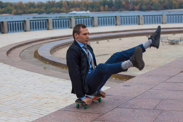 businessman in business suit in the city with skateboard