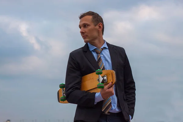 businessman in business suit in the city with skateboard