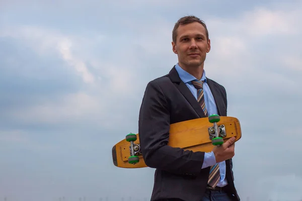 businessman in business suit in the city with skateboard