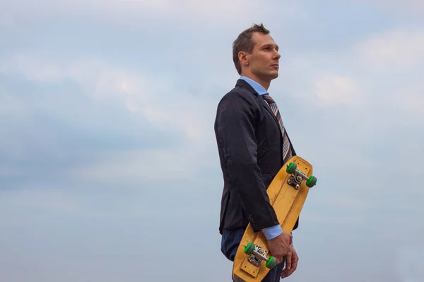 businessman in business suit in the city with skateboard