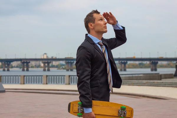 businessman in business suit in the city with skateboard
