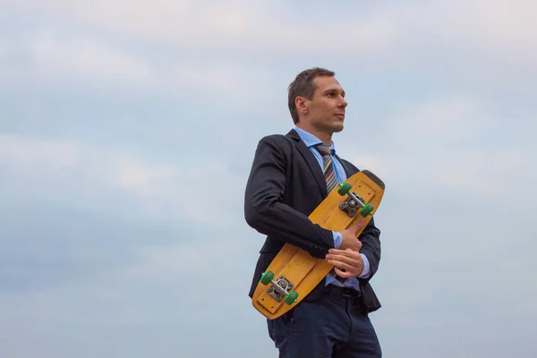 businessman in business suit in the city with skateboard