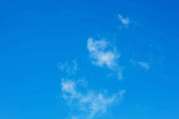 White clouds in the blue sky in sunny weather. Interesting abstract background of white clouds and blue sky.