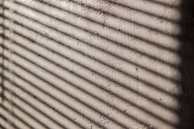 Güneşlikler beton duvardan bir gölge ile ilginç arka plan.