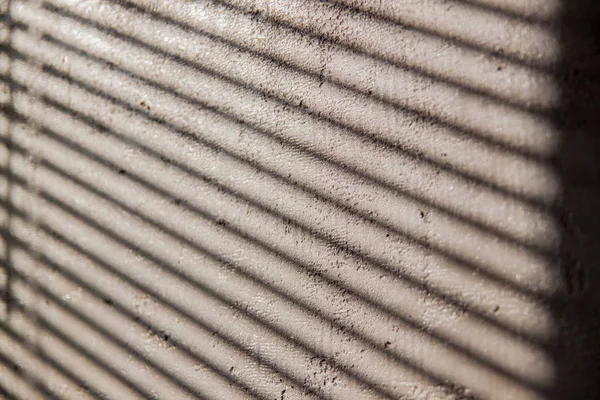 Güneşlikler beton duvardan bir gölge ile ilginç arka plan.