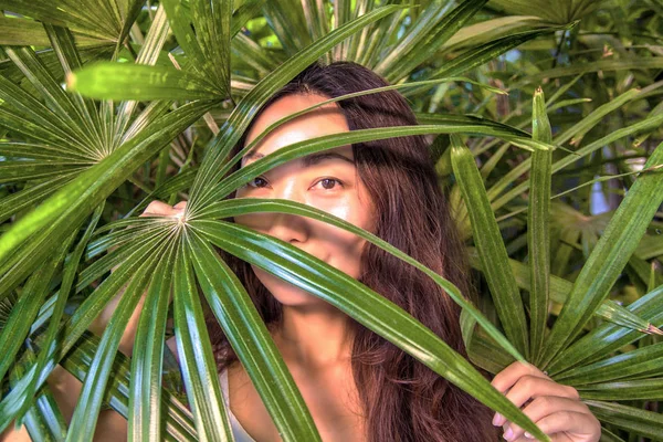 Bir kadın palmiye yaprakları saklanıyor. Doğu güzellik ve Cilt Bakımı.