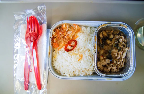 Set of inflight meal in a box, on the folding table in economy class. Feeding the passengers of Asian food on the plane . The journey tour, on the plane. food set close-up top view.