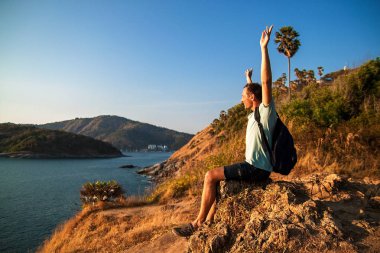 Gün batımında kaldırdı elleriyle bir tepe üstünde duran sırt çantası ile turizm.