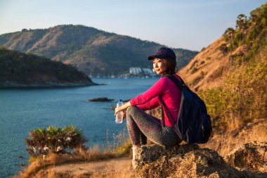 Yalnız kadın backpacker su bir içki için durur ve bir dağın tepesinden görünümü sahiptir .