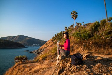 Yalnız kadın backpacker su bir içki için durur ve bir dağın tepesinden görünümü sahiptir .