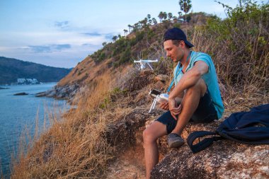 Gün batımında denizin üzerinde uçan insansız hava aracı. İnsan ıslığı havadan indiriyor. Gün batımı fotoğraf havadan.