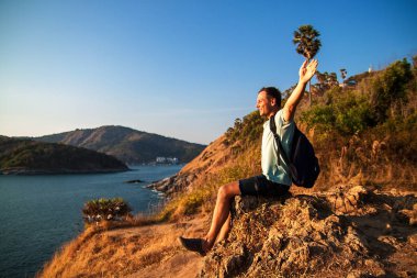 Gün batımında kaldırdı elleriyle bir tepe üstünde duran sırt çantası ile turizm.