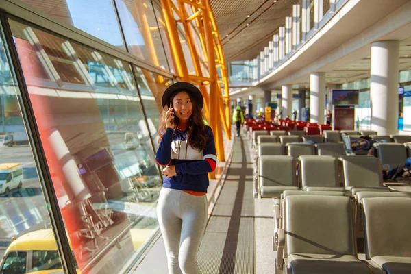 Ασιάτης Ισσα Γυναίκα Χρησιμοποιώντας Κινητό Τηλέφωνο Στο Αεροδρόμιο Κοιτάζοντας Έξω — Φωτογραφία Αρχείου