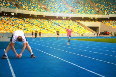 Bir grup sporcu stadyumda eksersises yapmak. Sporcular antrenmandan sonra dinlendi.