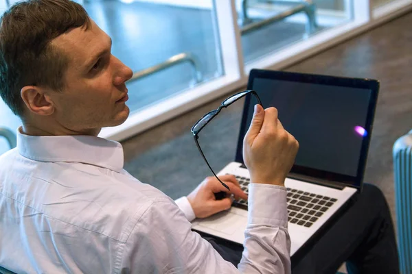 Havaalanında wi-fi internet kullanarak bir dizüstü bilgisayar üzerinde çalışan beyaz iş adamı. 