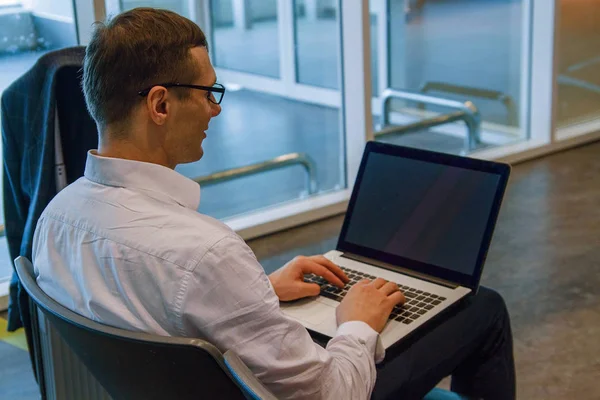 Havaalanında wi-fi internet kullanarak bir dizüstü bilgisayar üzerinde çalışan beyaz iş adamı. 