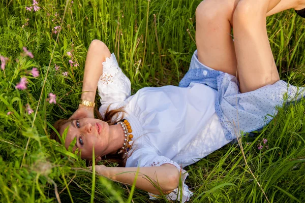 年轻的金发女子躺在绿草上 自由和放松的概念 自由和放松的概念 柔和的焦点 老式的色调 — 图库照片
