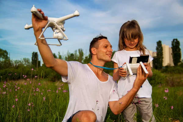 outdoor recreation Leisure for family. Birthday gift. A man and little girl launch a radio-controlled aircraft or a drone or a helicopter into the sky.