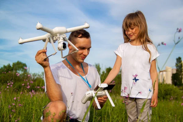 outdoor recreation Leisure for family. Birthday gift. A man and little girl launch a radio-controlled aircraft or a drone or a helicopter into the sky.