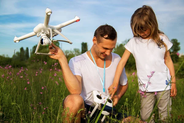 outdoor recreation Leisure for family. Birthday gift. A man and little girl launch a radio-controlled aircraft or a drone or a helicopter into the sky.