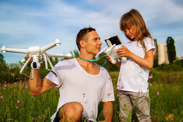 outdoor recreation Leisure for family. Birthday gift. A man and little girl launch a radio-controlled aircraft or a drone or a helicopter into the sky.