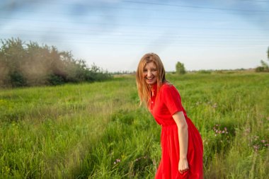 Yaz aylarında doğada çiçekler ile genç güzel sarışın kadın güleryüzlü.