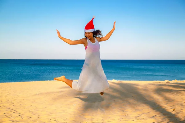 Vrouw Springen Strand Dragen Kerstmuts — Stockfoto