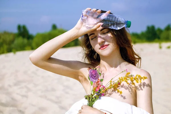 美丽的女人在沙漠里喝瓶子里的水 炎热的天气和如何逃离热 — 图库照片