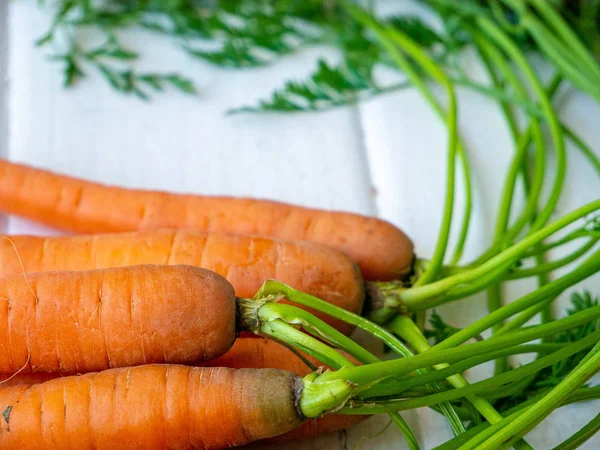 Kökleri ve üst kısımları yatay olan taze havuçlara çok yakından bakın..