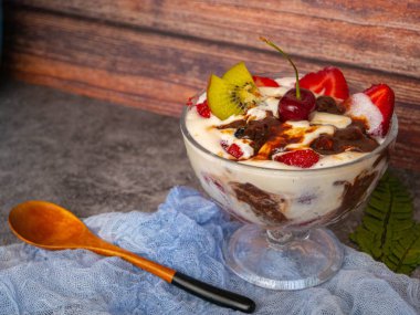 Cam vazoda çilekli dondurma ve çikolata. Gri dokulu arka plan. Tatlı. Besin zinciri.