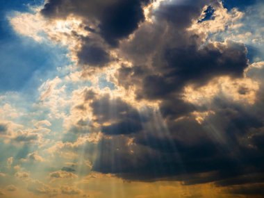 Güneş ışınları gökyüzündeki bulutları kırar. Arka plan görüntüsü.