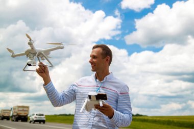 Genç adam alanındaki dron kontrol. Bir verici tutan dron işleç.