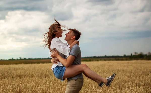 フィールドを歩くロマンチックなカップル 日当たりの良い農村で抱き合う愛情深い若いカップル — ストック写真