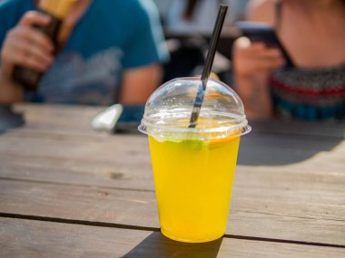 bir bardak buz küpleriyle soğuk turuncu limonata limon dilimi ile servis.