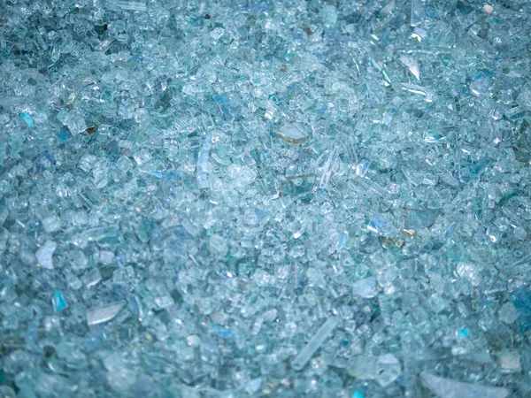 Background of clear glass broken into pieces. Close-up broken glass pieces.