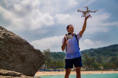 Adam bir dron sahilde uzaktan kumanda ile çalışma.