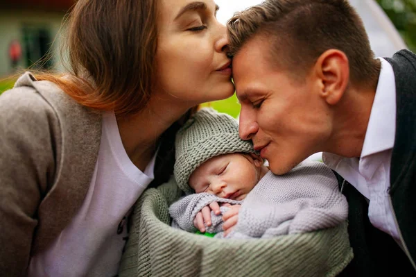 Family and new born baby, parents holding newborn child.