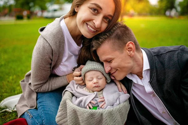 Family and new born baby, parents holding newborn child.