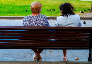 Ulusal parkta bir bankta oturan iki yaşlı kadın..