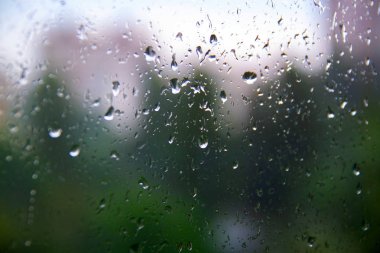 ofis penceresi yağmur suyu ile kaplı. pencerede su spreyi. yağmur trafiğinden sonra, işçi ofis kavramları sıkışmış. kentsel ufuk çizgisi arka planı bulanıklaştırır. yağmurlu mevsim kavramları.