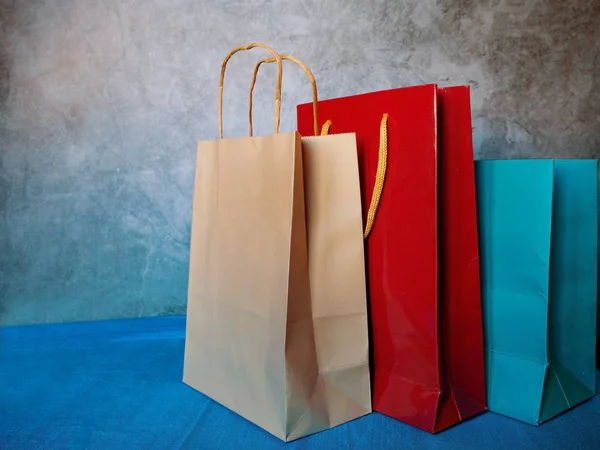 Close up paper gift bags with rope handles. Three blank carry bags on white background, cropped image.