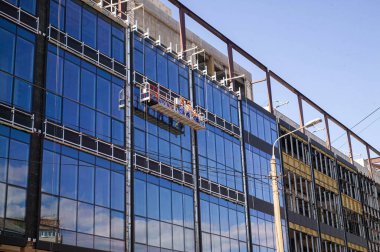 Cam bir binanın dış duvarlarında yüksek irtifa çalışması.