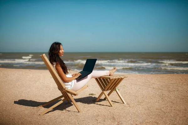 young beautiful asian businesswoman independent woman working with laptop and enjoying beach view on vacation.